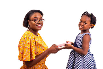 close-up of a charming woman giving a book to her daughter, smiling.