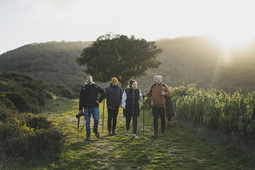 Group of friends walking along the green route during the hike in the peak of La sierra, Andaluza - obrazy, fototapety, plakaty
