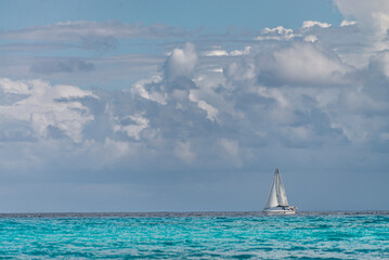 White sailboat navigating on the Turquoise Caribbean waters