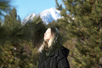 Teenage girl on the background of mountains on a sunny day