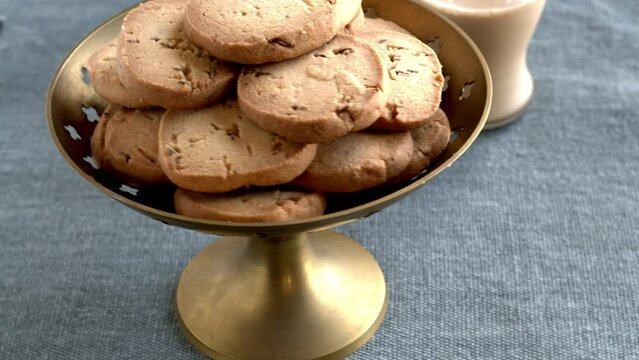 Home-baked biscuits jeera cumin biscuits and masala chai. Table spin.