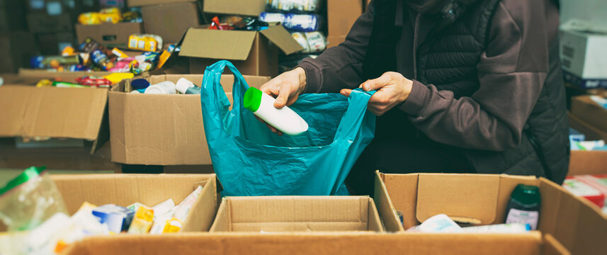 The volunteer packing the bag with groceries and necessary things for people in need