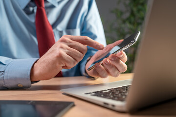 Fototapeta premium Businessman using smartphone and laptop computer