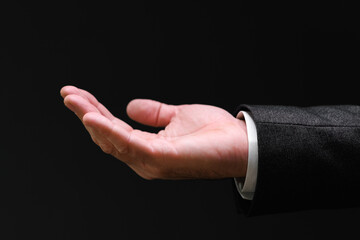 Businessman pleading hand reaching out from the dark