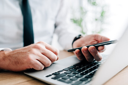 Diligent Businessman Reading Text Message Notification While Working On Office Laptop Computer