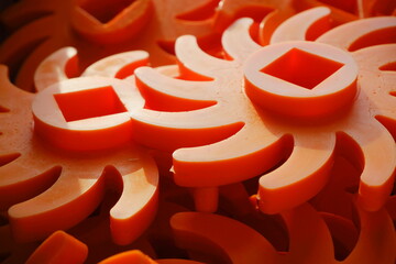 Orange elements of the disk separator of bulk products.Plastic orange stars close-up.Disk separator...