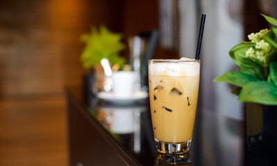 White cup of ice coffee waiting for customer on counter bar in modern cafe coffee shop. Coffee Break.