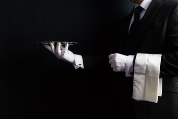 Profile Portrait of Butler or Waiter in Dark Formal Suit and White Gloves Holding Serving Tray. Concept of Service Industry and Professional Hospitality.