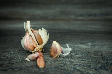 Czosnek, ząbki czosnku. Tłem dla aranżacji jest drewniana deska.