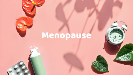 Menopause, text in pink frame. HRT Replacement hormone therapy concept. Pink background with exotic leaves, flowers, pills, estrogene gel. Sunlight, long floral shadows. Panoramic banner image. - obrazy, fototapety, plakaty
