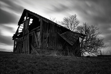 Side view of an old spooky abandoned barn