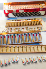 Parts of a disassembled accordion in process of restoration and repair with the set of tabs 