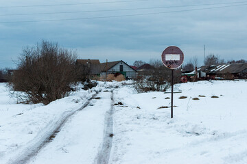 View of an old rusty minus sign in the middle of a rural or suburban area in winter