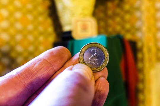 Closeup of a hand holding a coin 2 litas