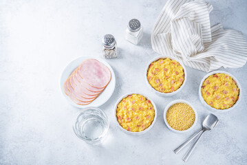 Cheesy millet with ham slices in a baking bowl