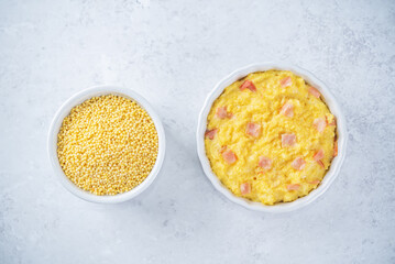Cheesy millet with ham slices in a baking bowl