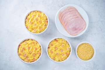 Cheesy millet with ham slices in a baking bowl