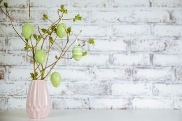 Decorative easter eggs on tree branches. branches decorated by easter eggs. Vase with tree branches...
