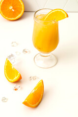 orange juice in a glass with ice, fresh fruit top view, blurred background