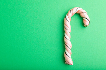 Single cane candy on green background. copy space, top view