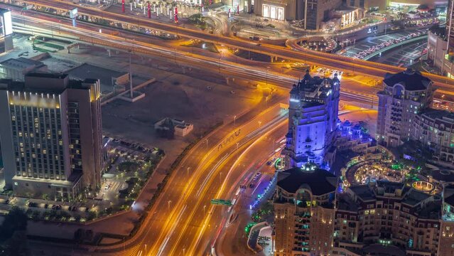Bussy traffic on the overpass intersection in Dubai downtown aerial night timelapse.