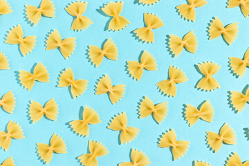 Uncooked italian farfalle pasta on a blue background. Top view.