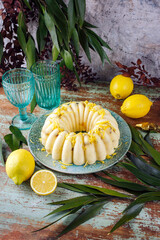 Traditioneller italienischer Budino di Ricotta Käsepudding Kuchen mit Rosinen und Zitronencreme serviert als close-up auf einem Design Teller mit Landhausstil Dekoration