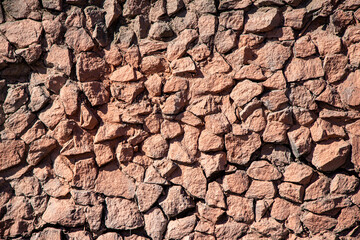 Background of a wall made of pieces of raw stone.
