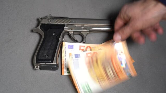 Money cash banknote  50 Euro and revolver gun army - order a murder, criminal underworld and social emergency delinquency  - mafia and criminal life