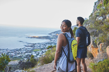 Youre my favourite view. Shot of a young couple enjoying the sunset view while out on a hike on a mountain range.