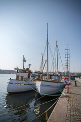 Old fishing boats at a pier in the bay Nybroviken a sunny spring day in Stockholm