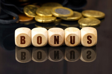 On a black surface are coins and cubes with the inscription - BONUS