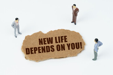 On a white background, figures of businessmen and torn cardboard with the inscription - NEW LIFE DEPENDS ON YOU