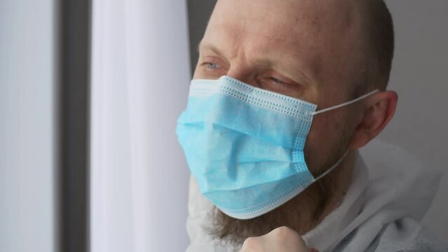 Close-up of an infectious disease doctor in protective clothing takes off his mask and goggles after a hard shift in the hospital. Heroes are doctors who fought back a dangerous disease in hospitals.