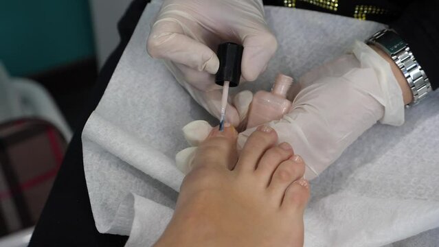 Piedi di una giovane donna che fa pedicure. Terapia del piede in una spa, Smalto sulle unghie, pulizia e taglio.