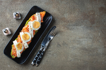 Traditional Spanish breakfast. Tostada with different toppings on a dark background. Top view with copy space