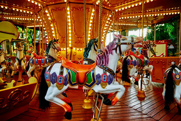Carousel with colorful horses at amusement park, Merry go round with horse, Vintage ride attraction...