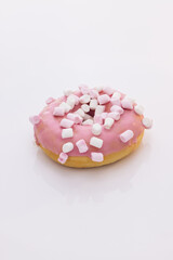 Bright and colorful sprinkled donut close-up shot on a white background. Assortment of donuts of different flavors. Pink glazed and sprinkles donut