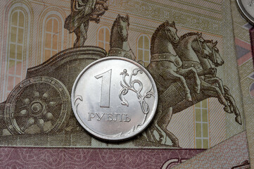 Russian coin with a face value of 1 ruble lies on a banknote. Translation of the inscriptions on...