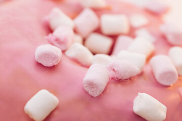 Obraz na płótnie Canvas Close up pink and white mini marshmallows on pink donut food light sweet dessert candy delicious sugar. Appetizing sweet donut dessert in pink glaze close-up