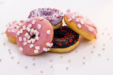Donuts of white background. concept art. Donuts of different colors. Glazed sweet desserts. Fast food, Bakery concept. Various colorful donuts. Chocolate, purple, pink donuts.