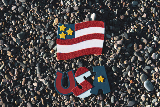USA small flag and USA lettering inscription on a rocky background. Independence day symbols, 4th July. USA super nation. 
