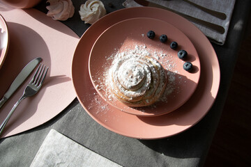 Croissants on a pink plate, sprinkled with powdered.decorated with berries.