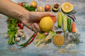 Plenty of vegetables and fruits. A man hands taking lemon from among them. Healthy life, loving yourself and balanced nutrition.