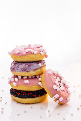 Tasty delicious sweet do nut with colorful sprinkles on white background. Shot of five sweet doughnuts stacked on top of each other in the form of a tower