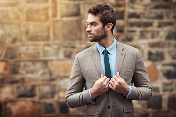 Looking slick. Shot of a handsome and stylish young businessman in an urban setting.