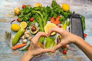 Healthy food with vegetables and fruits. A girl hands making heart sign. Healthy life, diet, loving...