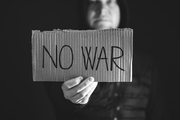 Man with No war banner sitting in the dark