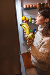Woman putting food in fridge after shopping