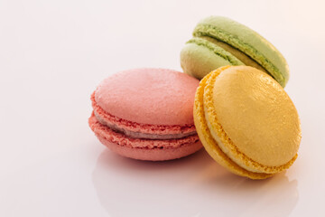 Three cookies macaroons are stacked on top of each other. Traditional French multicolored macaroon. Macaroons on white background. Food concept.